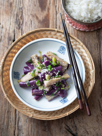 Korean eggplant side dish is presented in a small serving dish with chopsticks.
