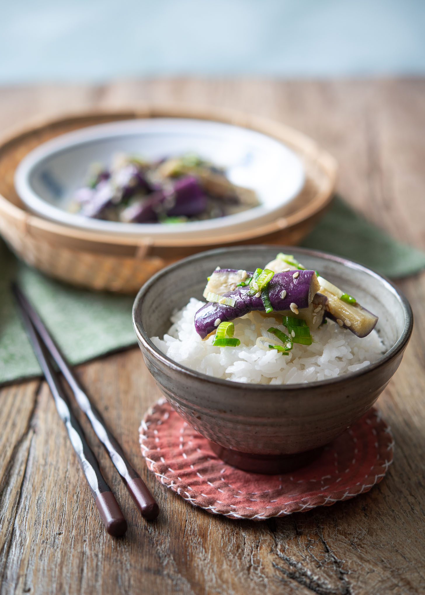 Korean eggplant side dish is served over a bowl of rice.