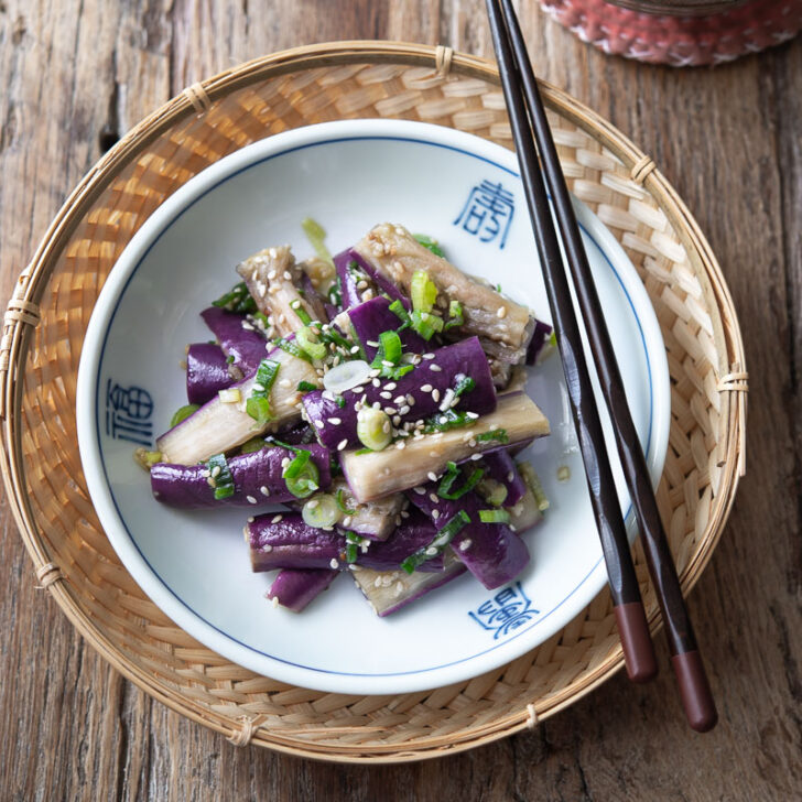 Korean eggplant side dish is presented in a small serving dish with chopsticks.