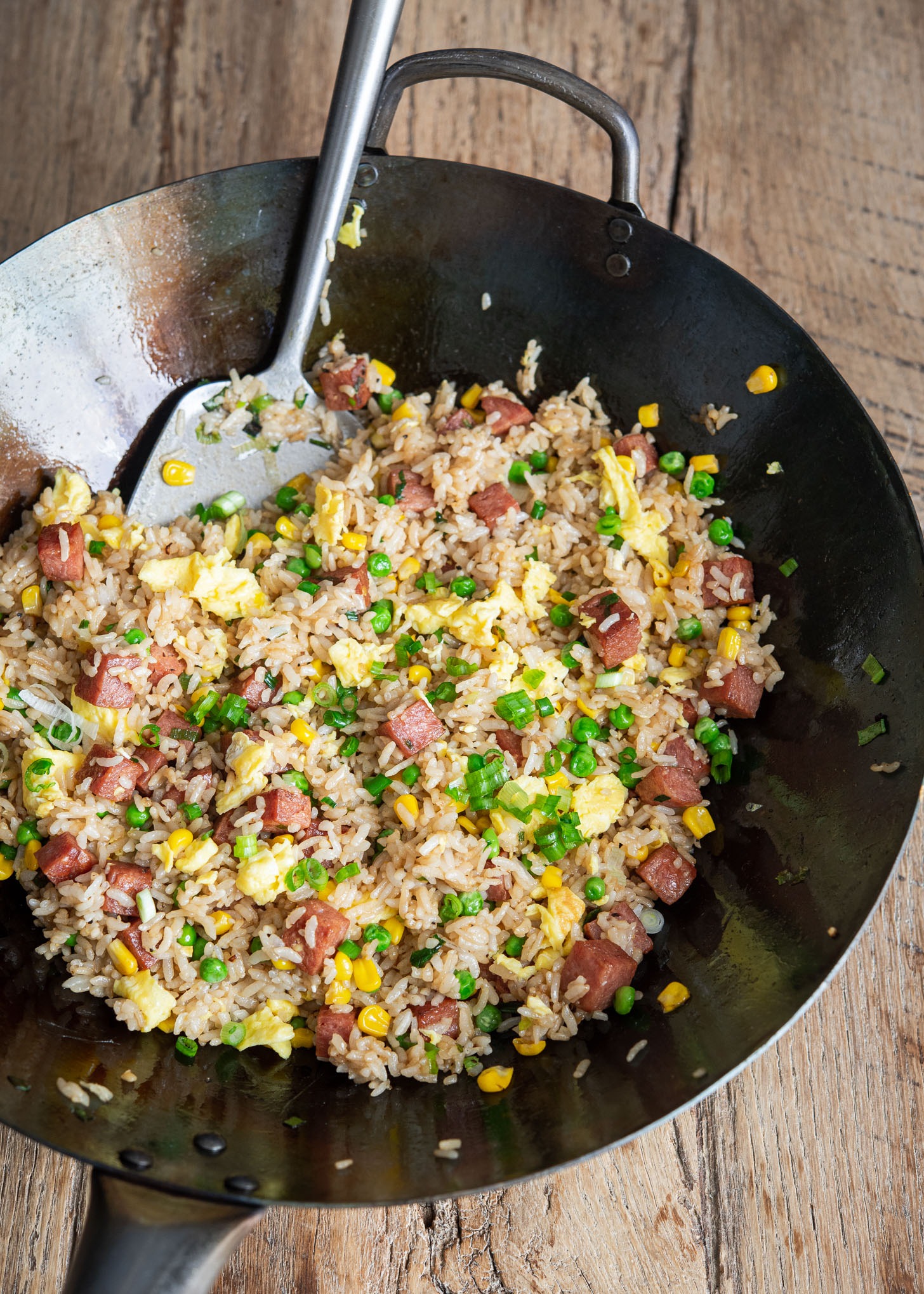 Spam fried rice is cooked in a wok.