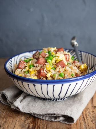 Spam fried rice is served in a bowl with a spoon