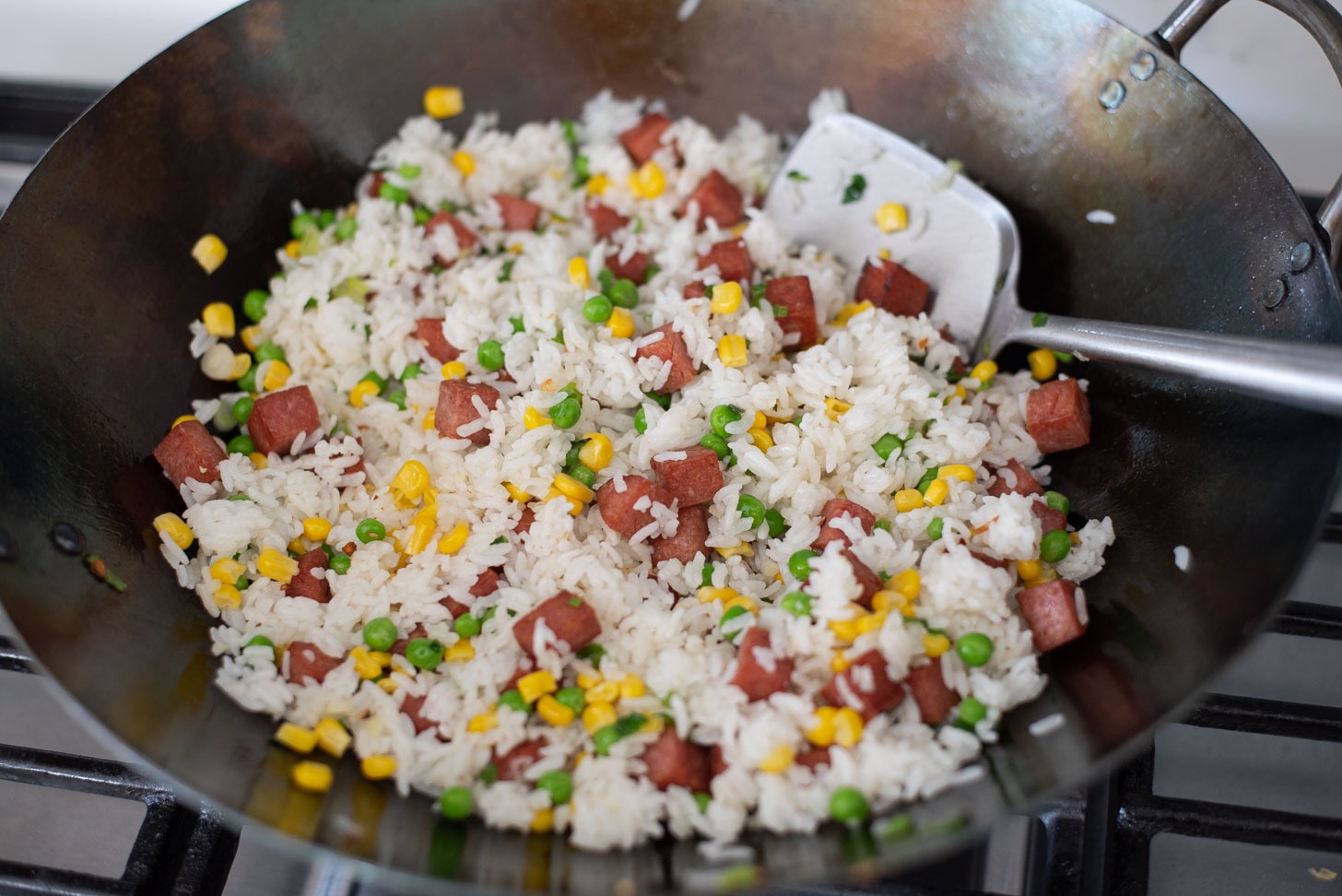 Rice is added to make Spam fried rice in a wok