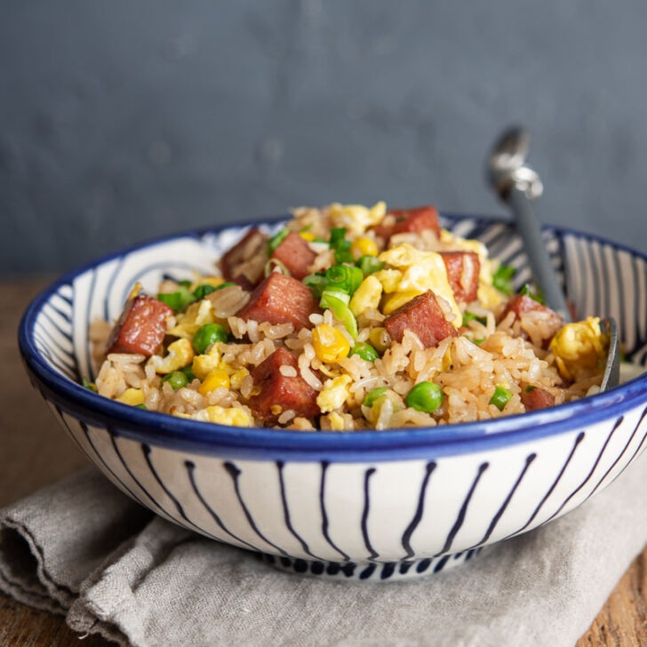 Spam fried rice is served in a bowl with a spoon