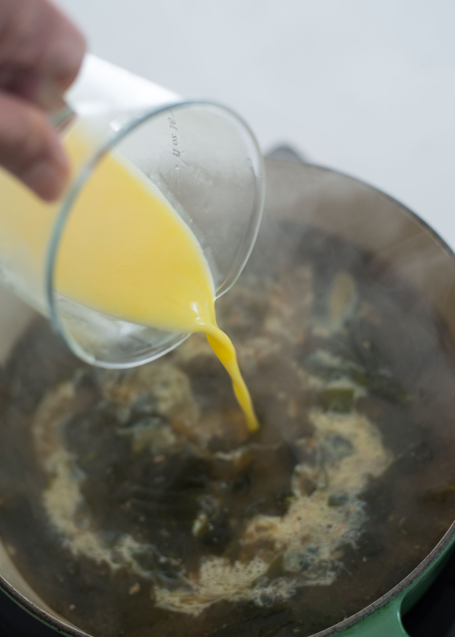Beaten eggs are slowly added and swirled in a seaweed soup.