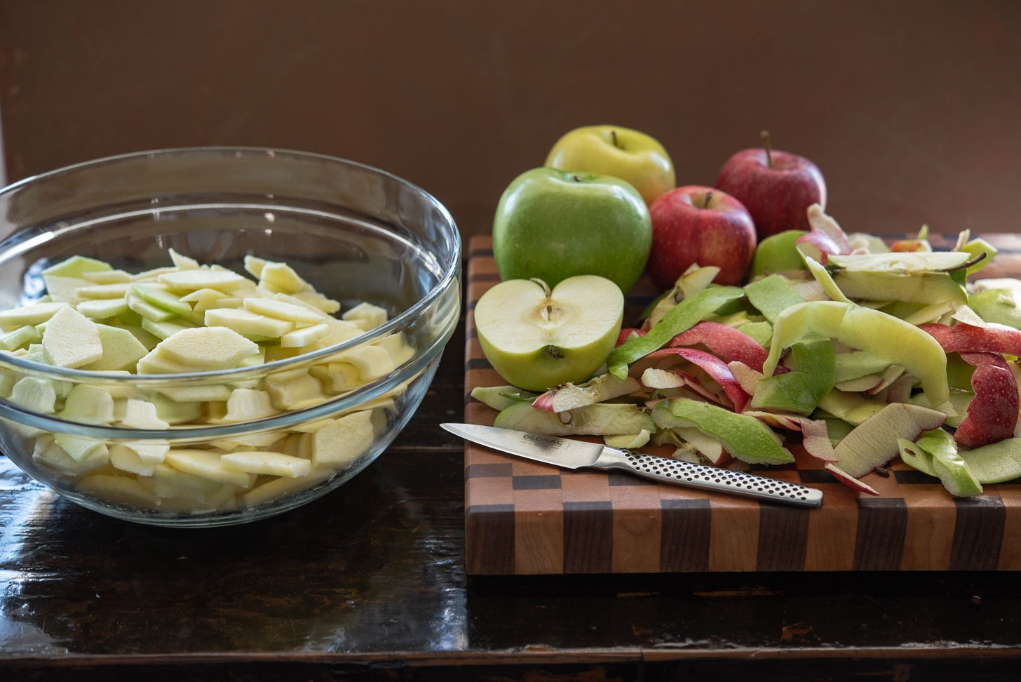 Various baking apples are peeled and sliced into small pieces.