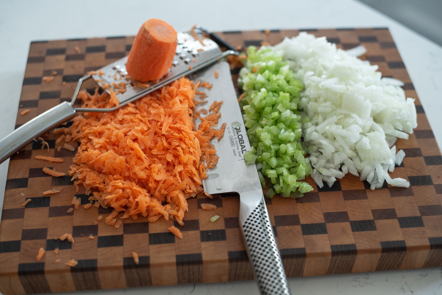 Onion, celery, carrot are finely chopped to make spaghetti sauce.