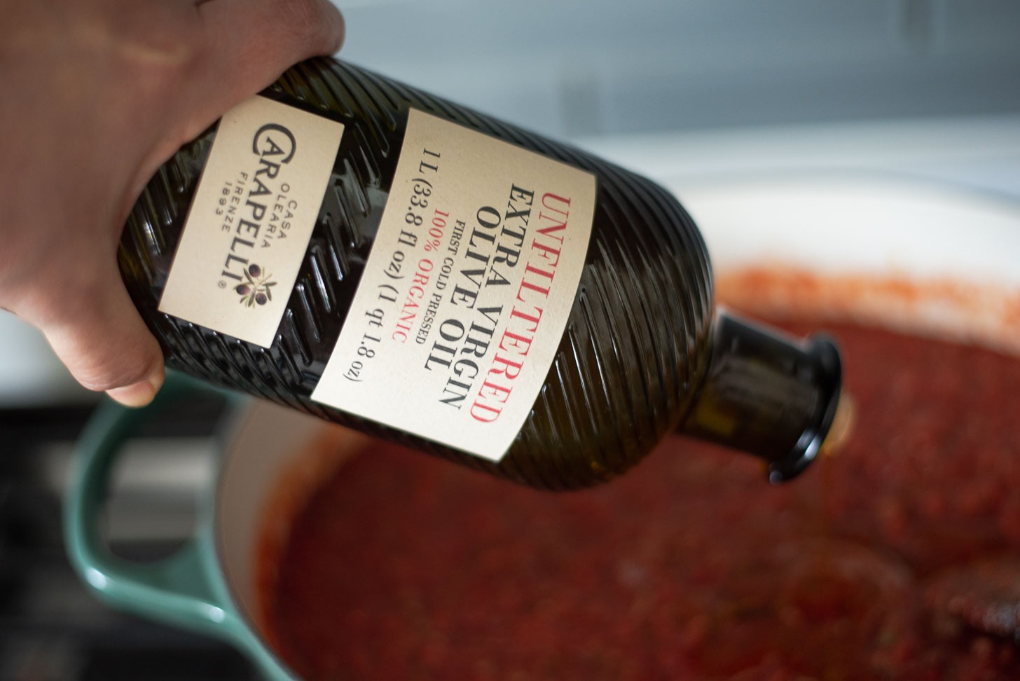 Olive oil is added to spaghetti sauce before simmering.