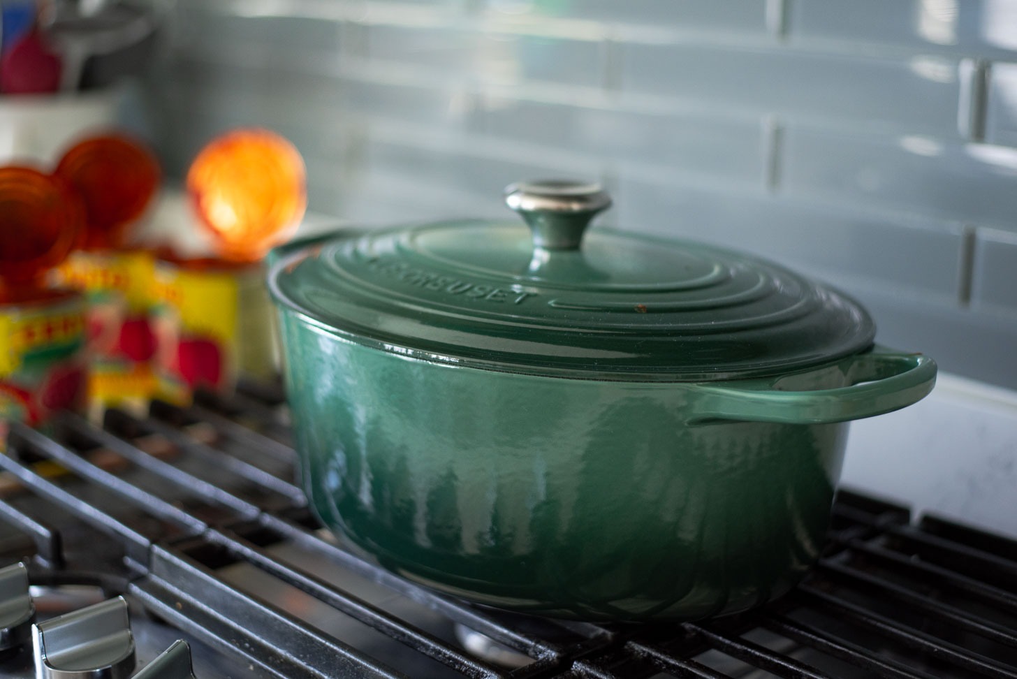 Homemade spaghetti sauce is simmering inside of a large dutch oven on the stove.