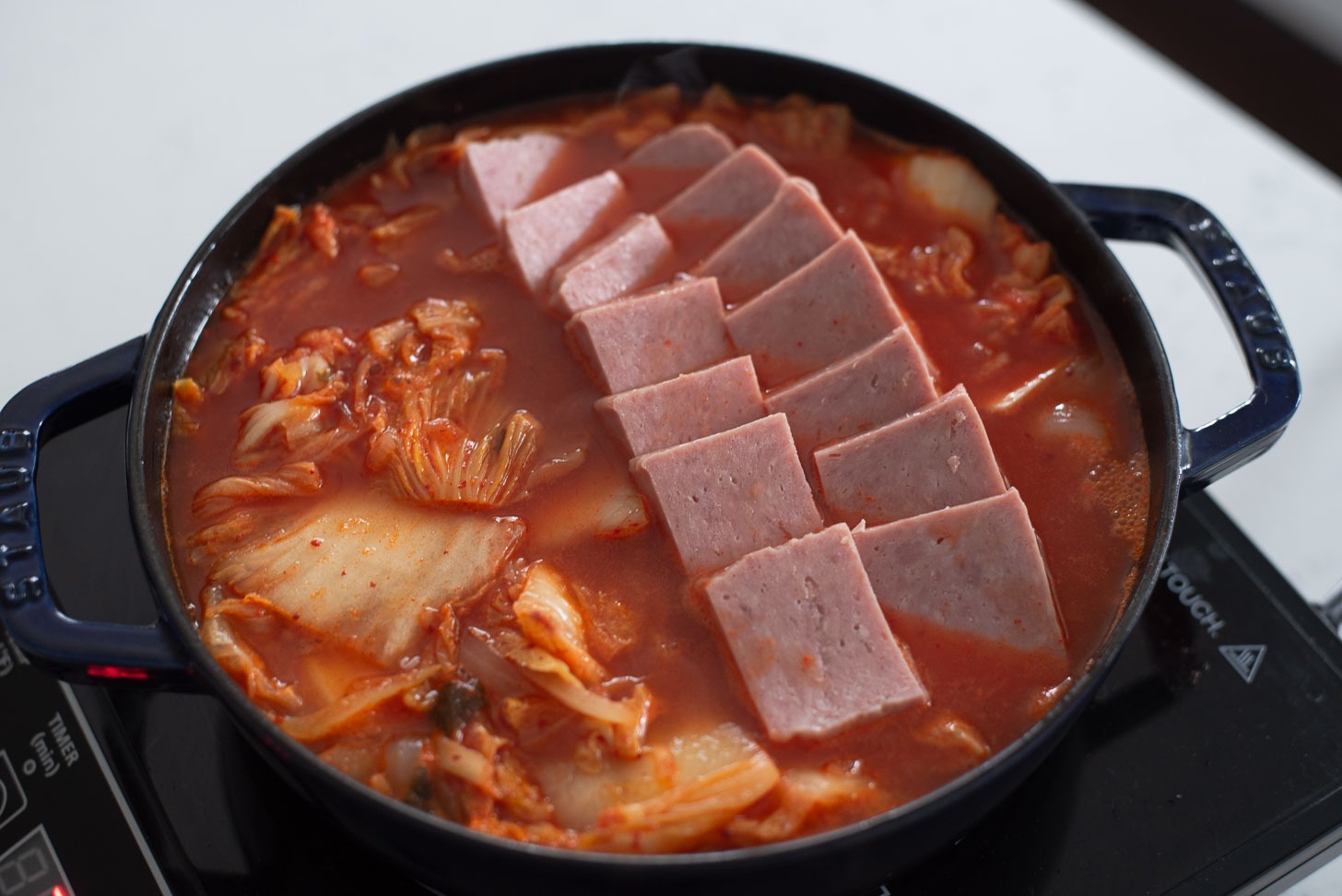 Spam slices arranged on top of kimchi stew (jjigae).