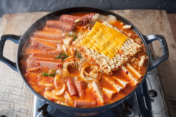 Korean army stew (budae jjigae) is boiling in a pot.