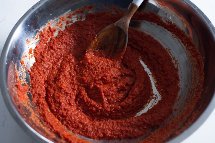 Kimchi paste with gochugaru is well mixed in a large container