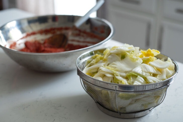 Drained cabbage and kimchi paste is ready to get mixed.