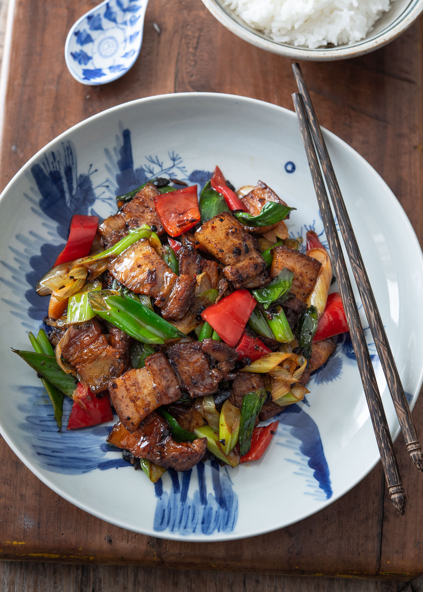 Twice cooked pork presented on a blue and white plate.