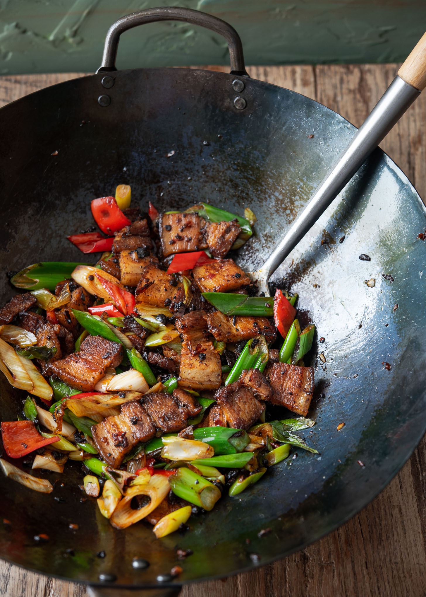 Twice cooked pork belly is prepared in a Chinese wok.
