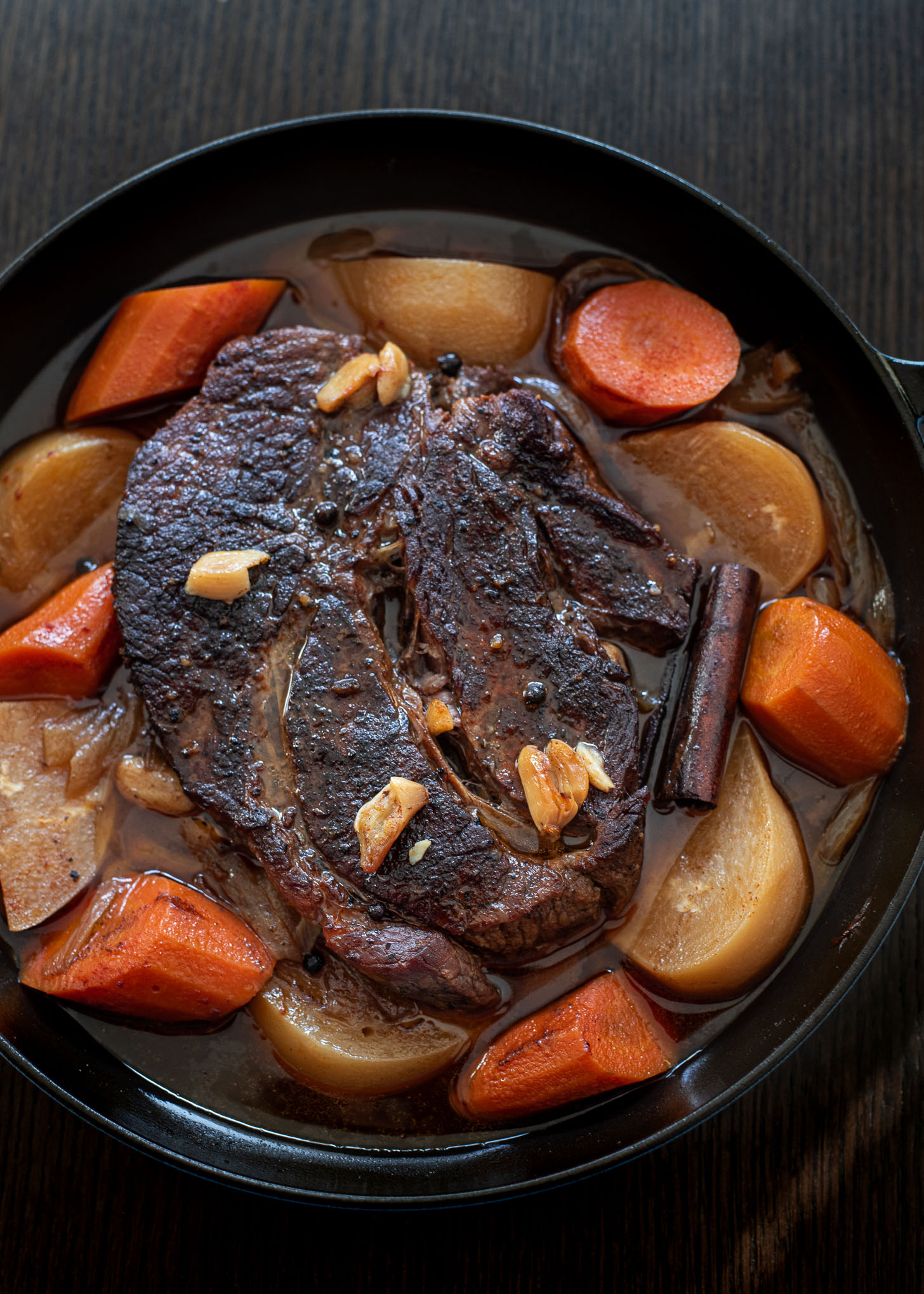 Beef chuck, carrot, onion, turnip are braised in a pan until soft.
