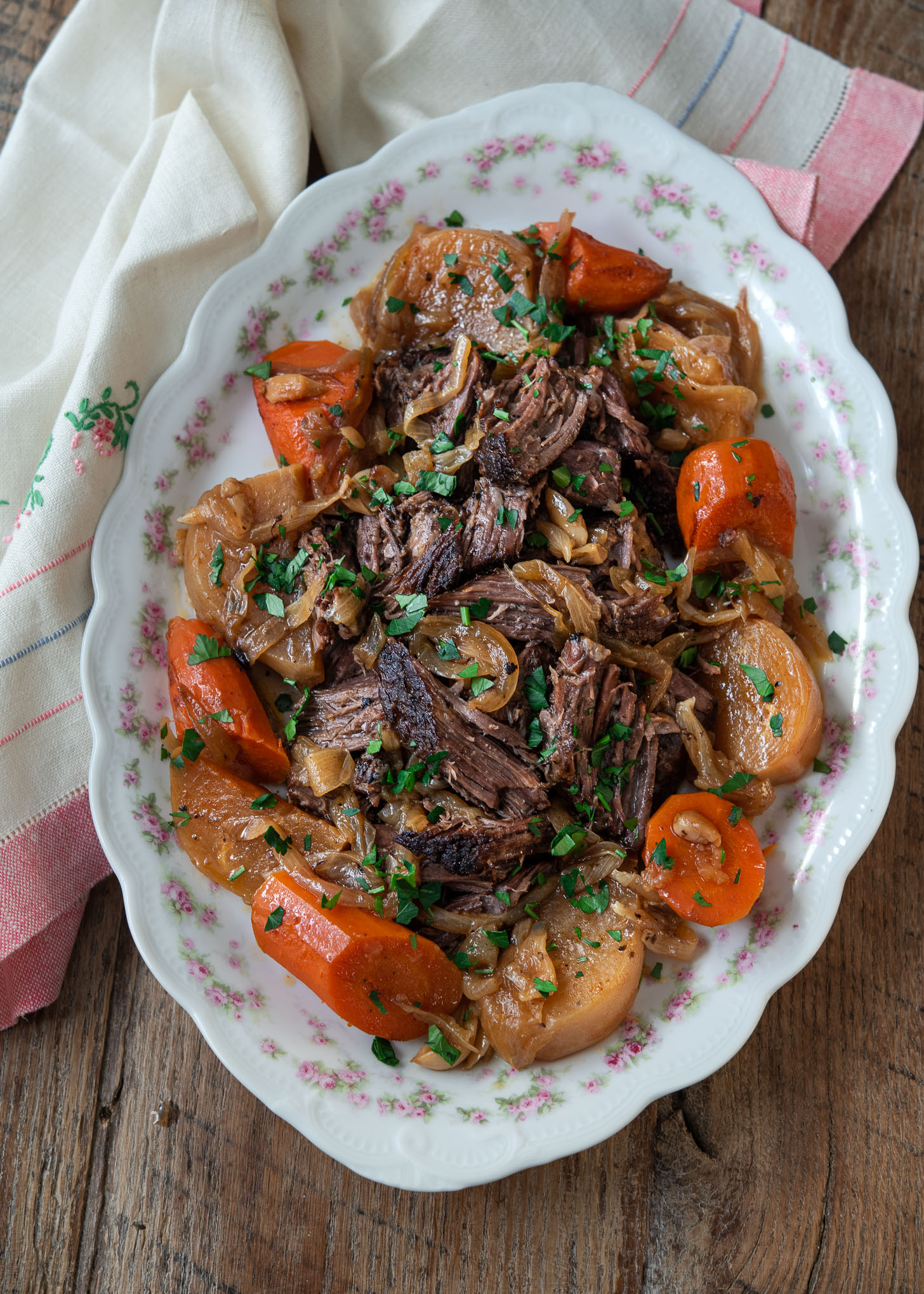 Spiced beef pot roast is served with carrot and turnip on a serving platter.