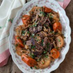 Spiced beef pot roast is served with carrot and turnip on a serving platter.