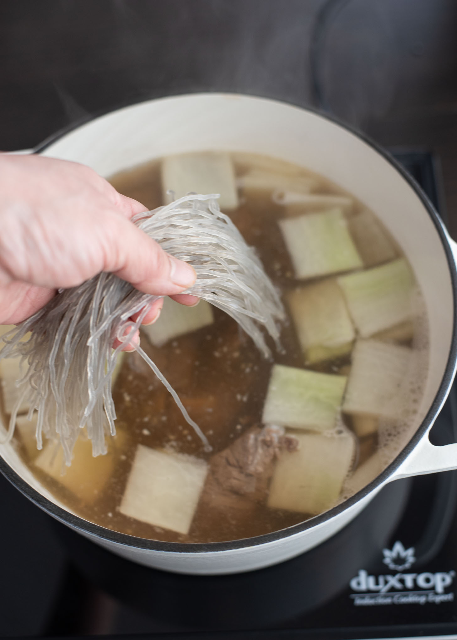 Soaked Korean glass noodles are added to galbitang to heat together.