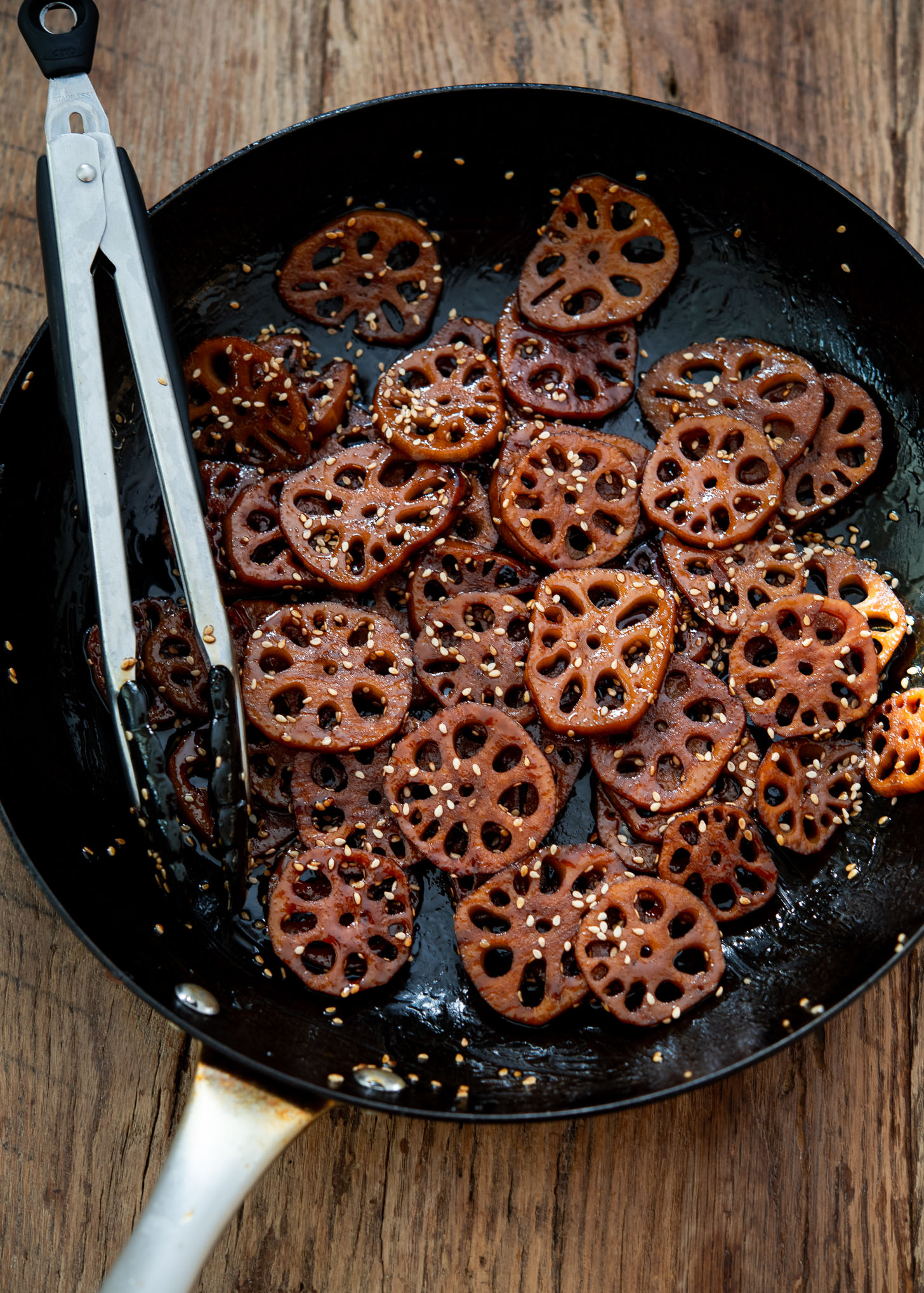 Braised and glazed lotus root side dish in a skillet