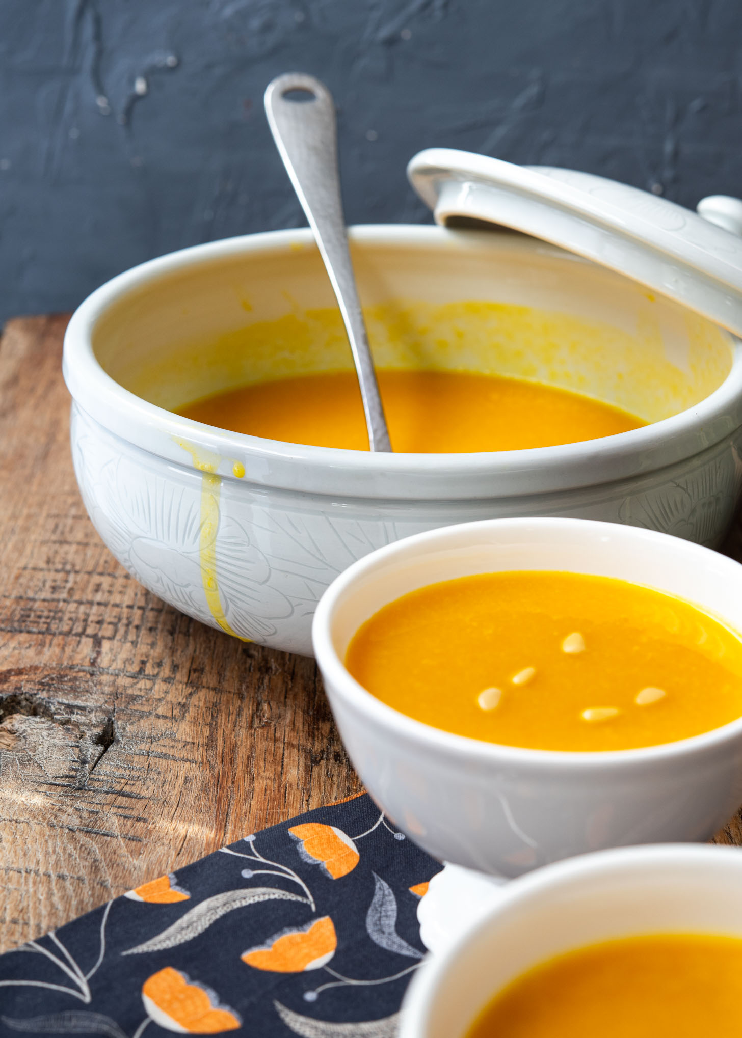 A large soup bowl and serving bowls are filled with Korean pumpkin porridge.