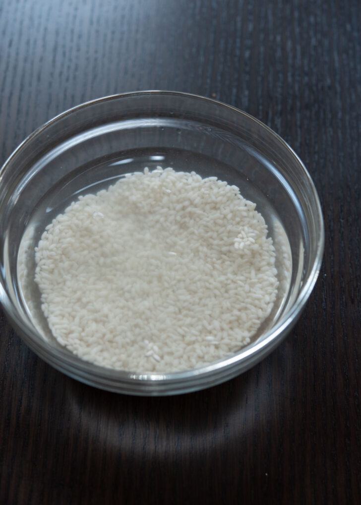 Sweet rice is soaking in water in a bowl.