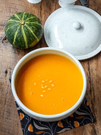 Korean pumpkin porridge is served in a large soup bowl with a lid.