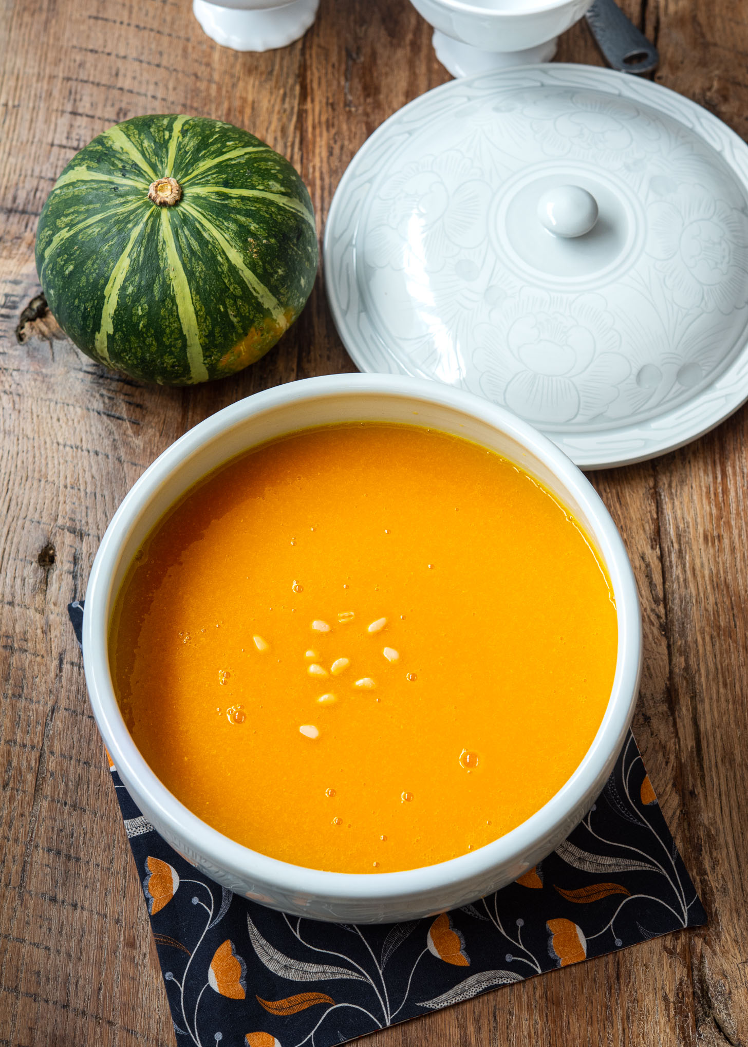 Korean pumpkin porridge (hobakjuk)  served in a large soup bowl garnished with pine nuts.