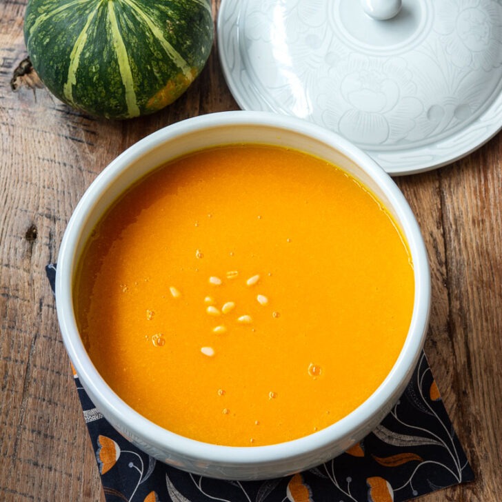 Korean pumpkin porridge is served in a large soup bowl with a lid.