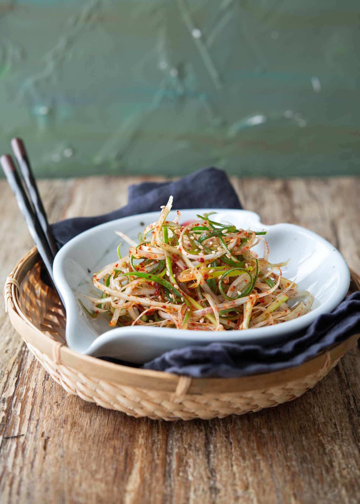 Korean green onion salad is served in a bowl over a wooden tray.