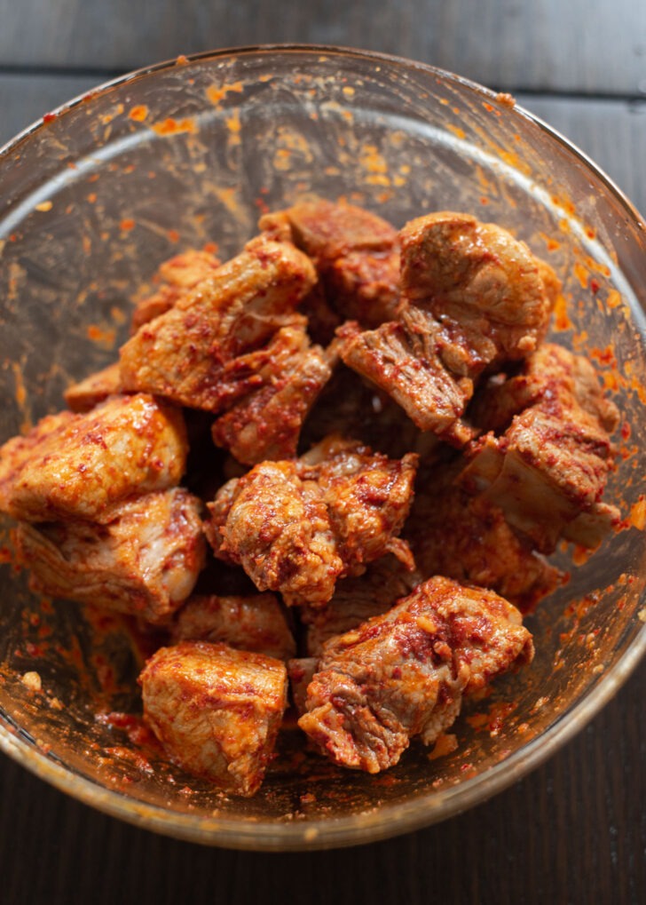 Pork ribs are coated with seasoning to make kimchi jjim.