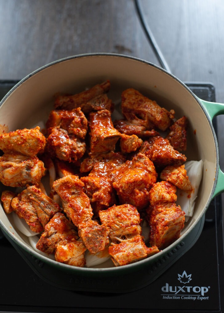 Seasoned pork ribs are placed on a pot.