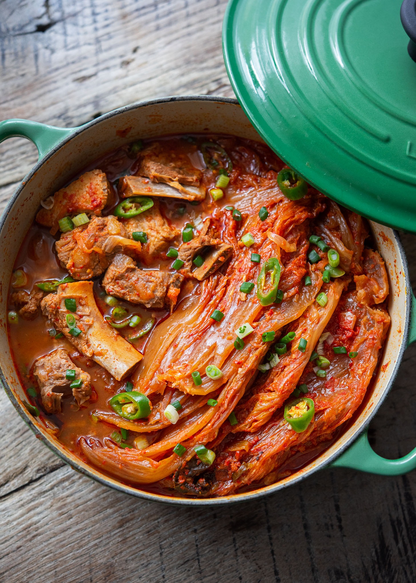 A pot of kimchi jjim is showing braised kimchi and pork ribs inside.
