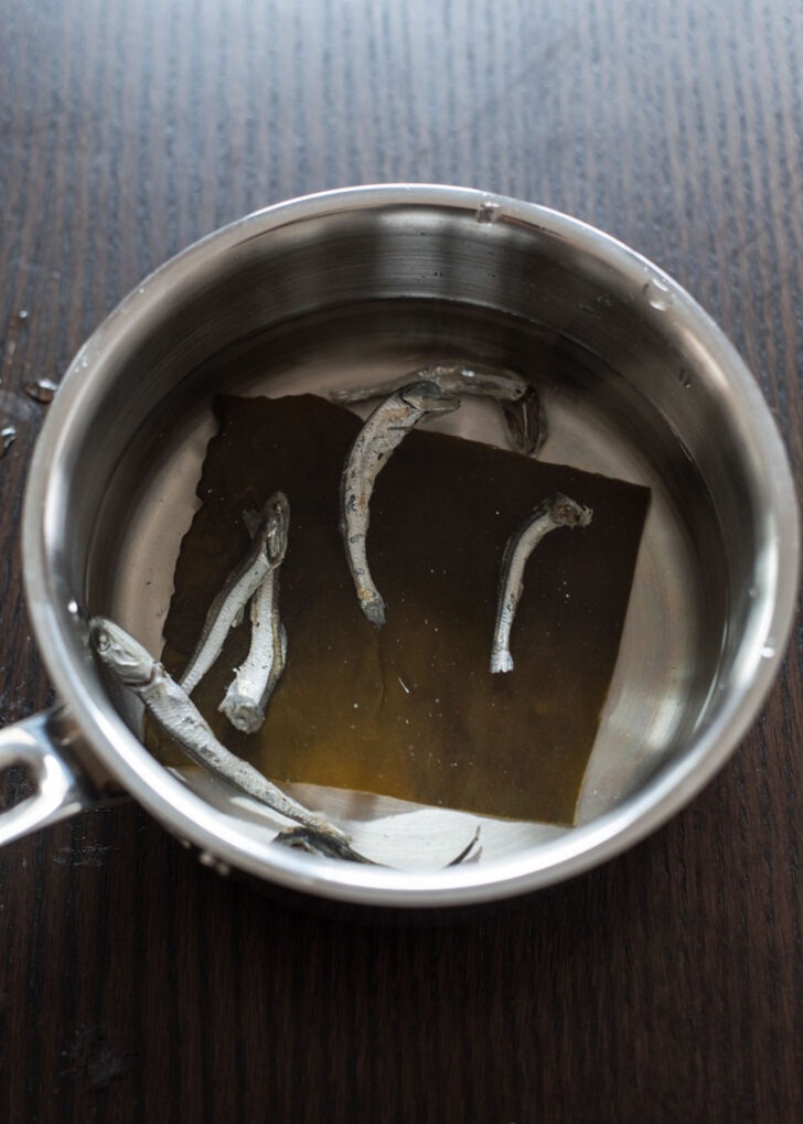 Dried anchovies and sea kelp are combined with water in a pot.