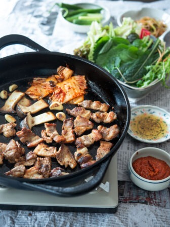 Korean BBQ table is filled with grilled samgyupsal and other side dishes.