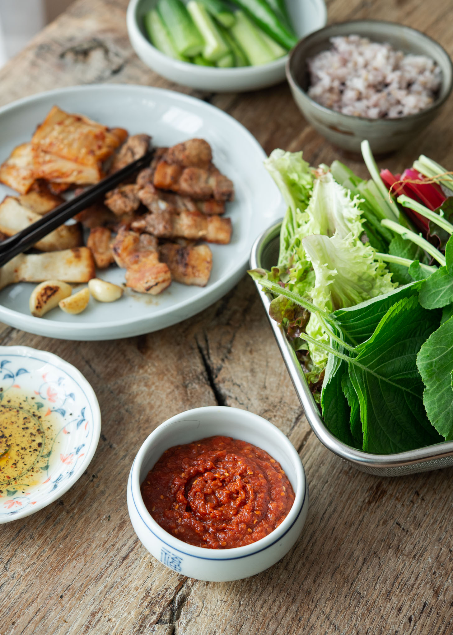 Ssamjang is served with Korean bbq pork belly and various lettuce.