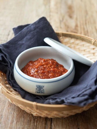 A bowl of ssamjang is presented with a lid on the side.