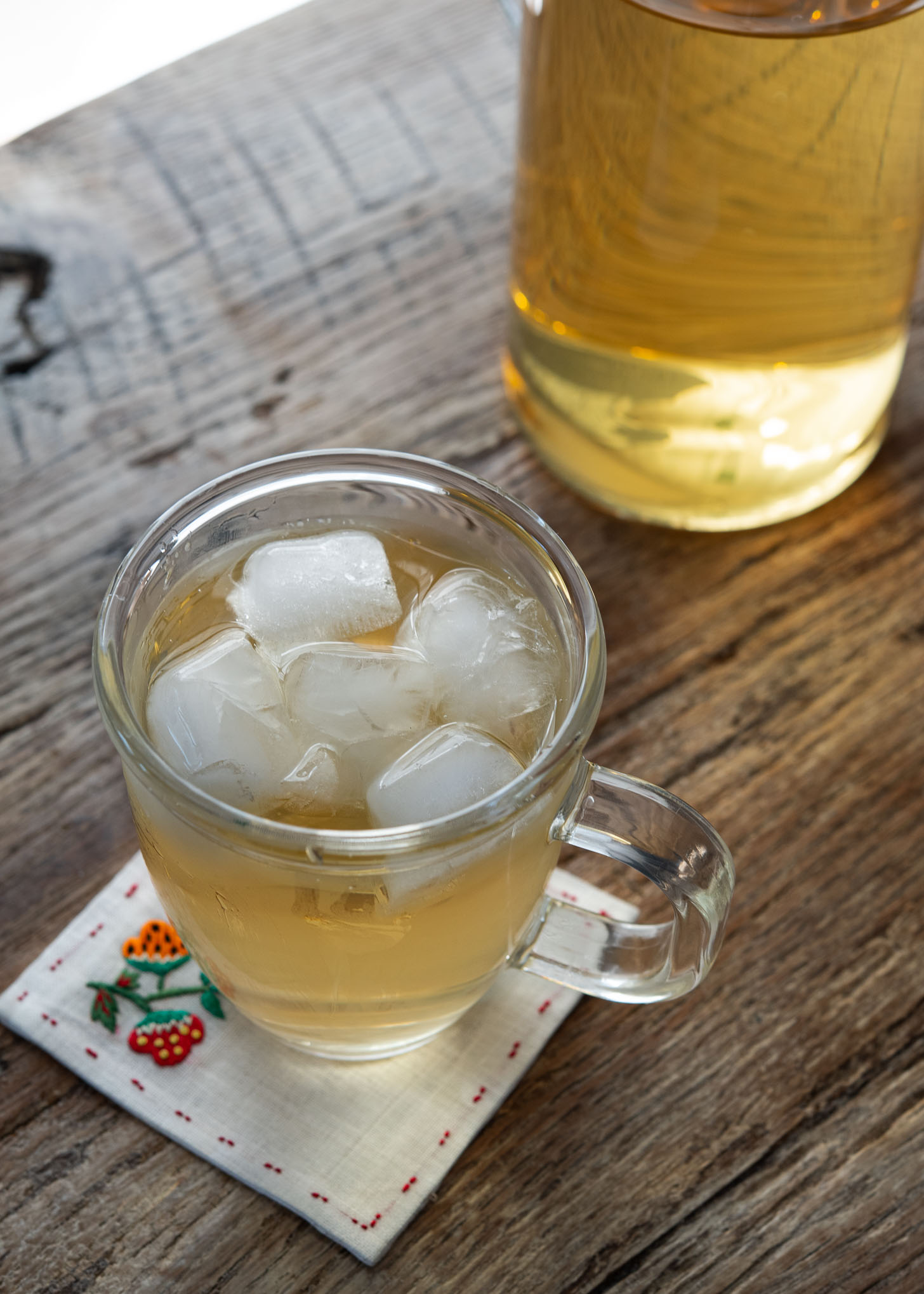 Cold Korean barley tea is garnished with ice cubes in a cup.