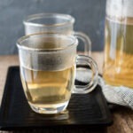 Steaming Korean barley tea is presented in glass cups on a tray.