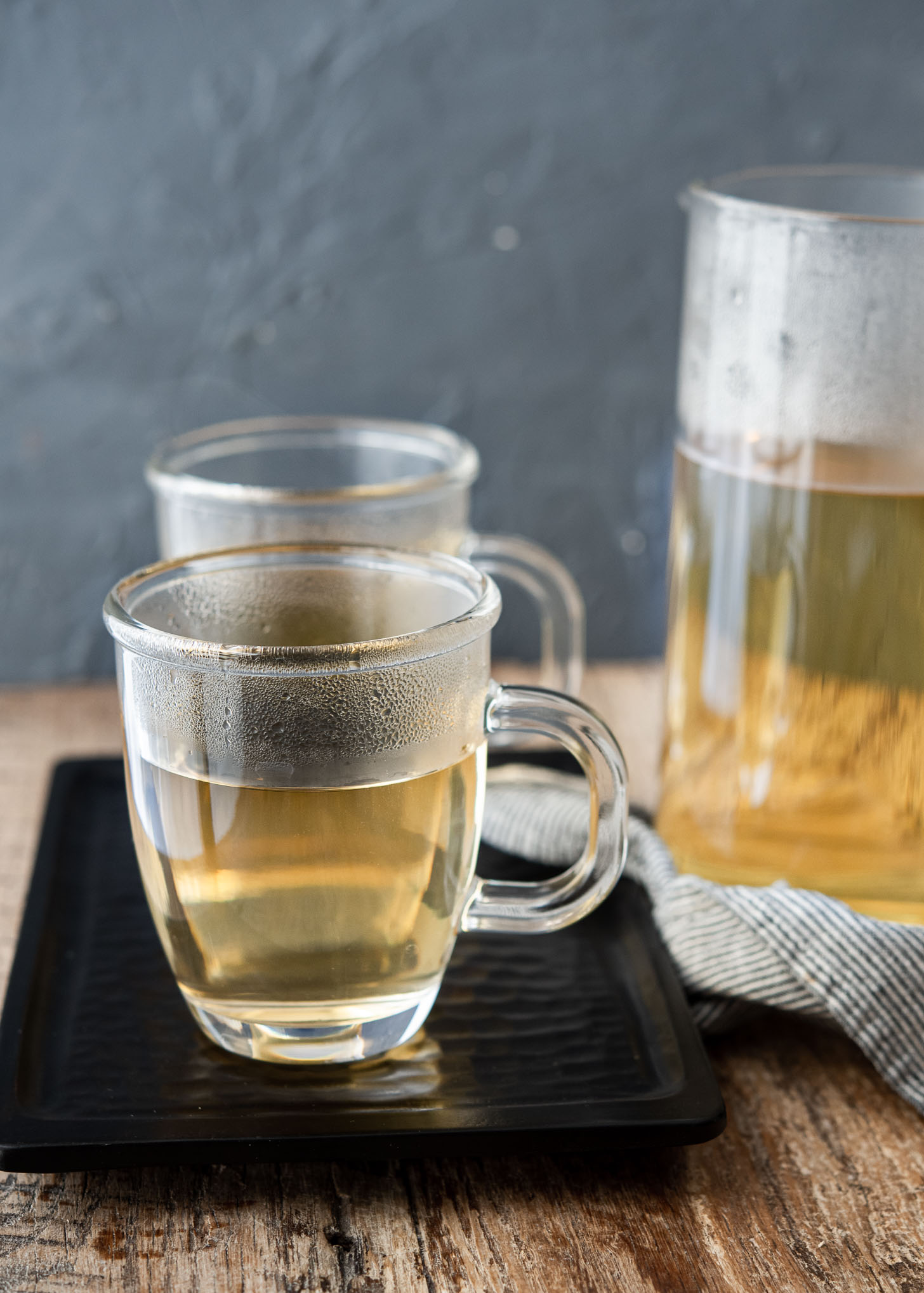 Steaming Korean barley tea in glass cups on a tray.