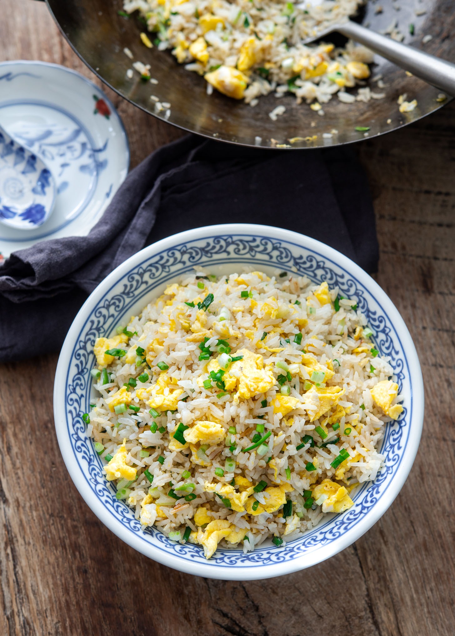 A bowl of egg fried rice is garnished with green onion.