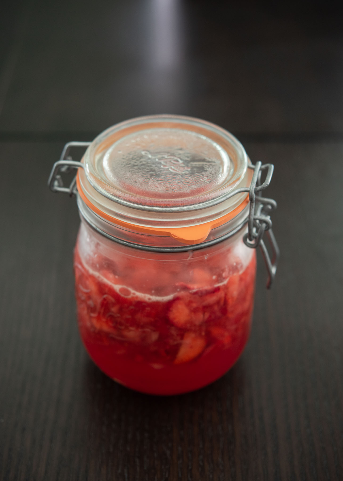A jar of fresh homemade strawberry syrup.