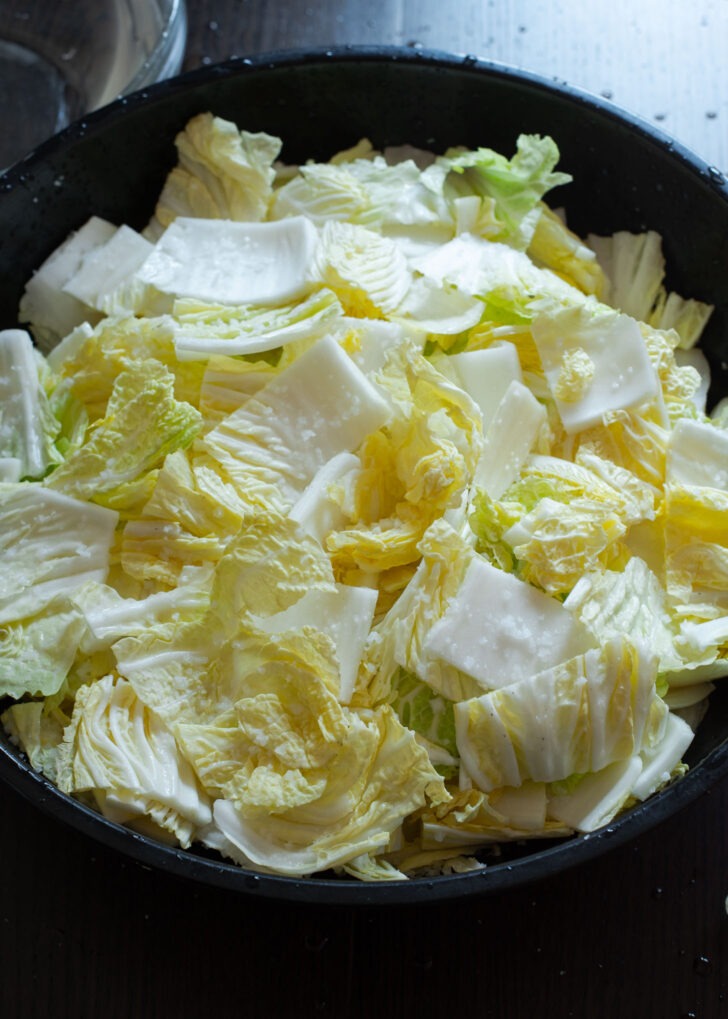 Sliced Napa cabbage pieces are being salted to make vegan kimchi.