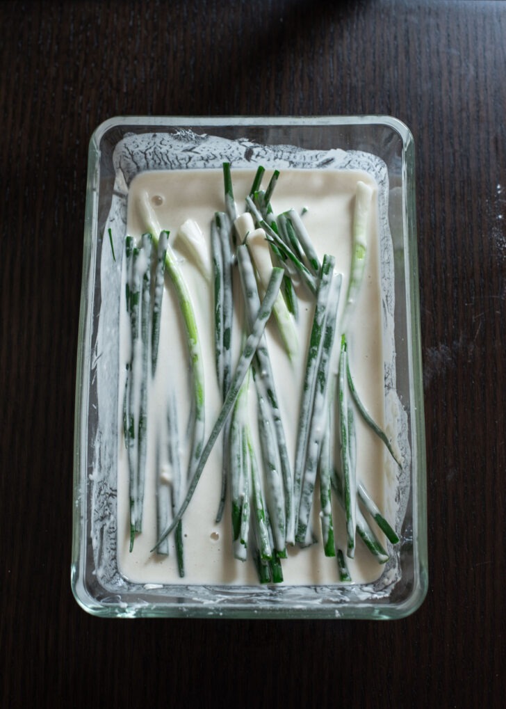 A bunch of trimmed green onion added to pancake batter.