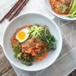 Bibim guksu (Korean cold noodles) garnished with salad vegetables and egg.