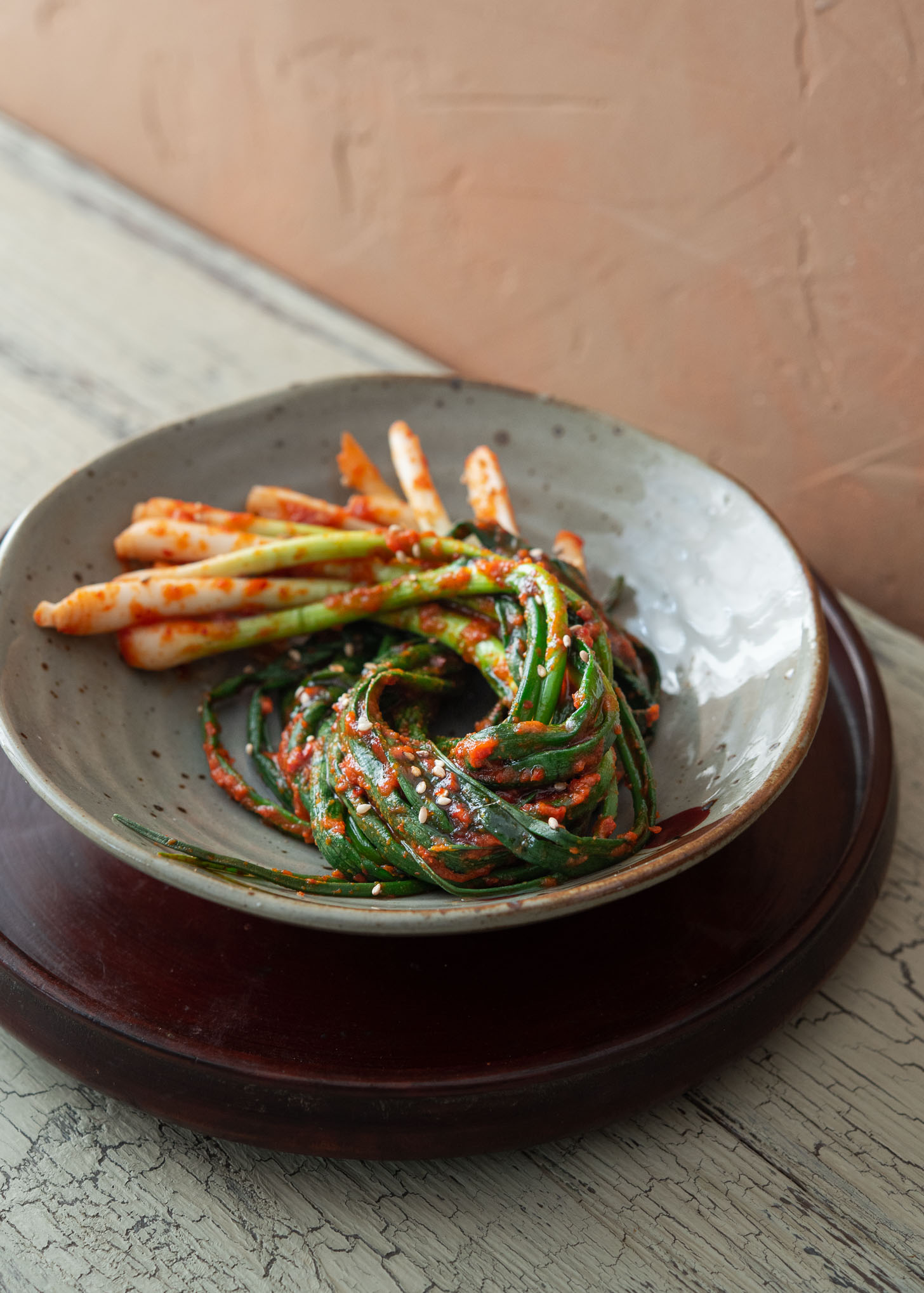 A bundle of Pa Kimchi is twirled in a small serving dish.