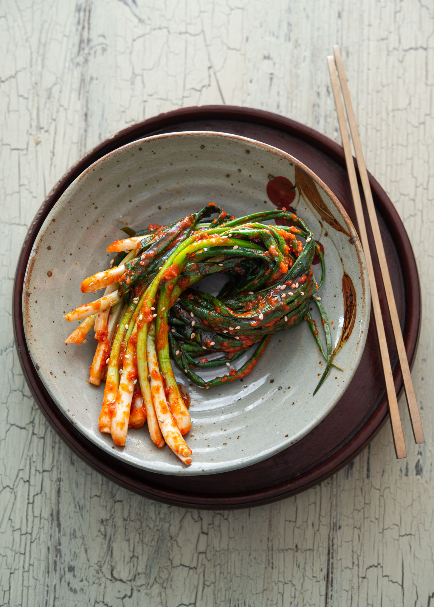 A bundle of Pa Kimchi is placed on a serving dish with a pair of chopsticks.