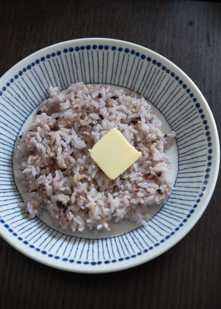 A thin sliver of butter topped over rice in a bowl to make gyeran bap.