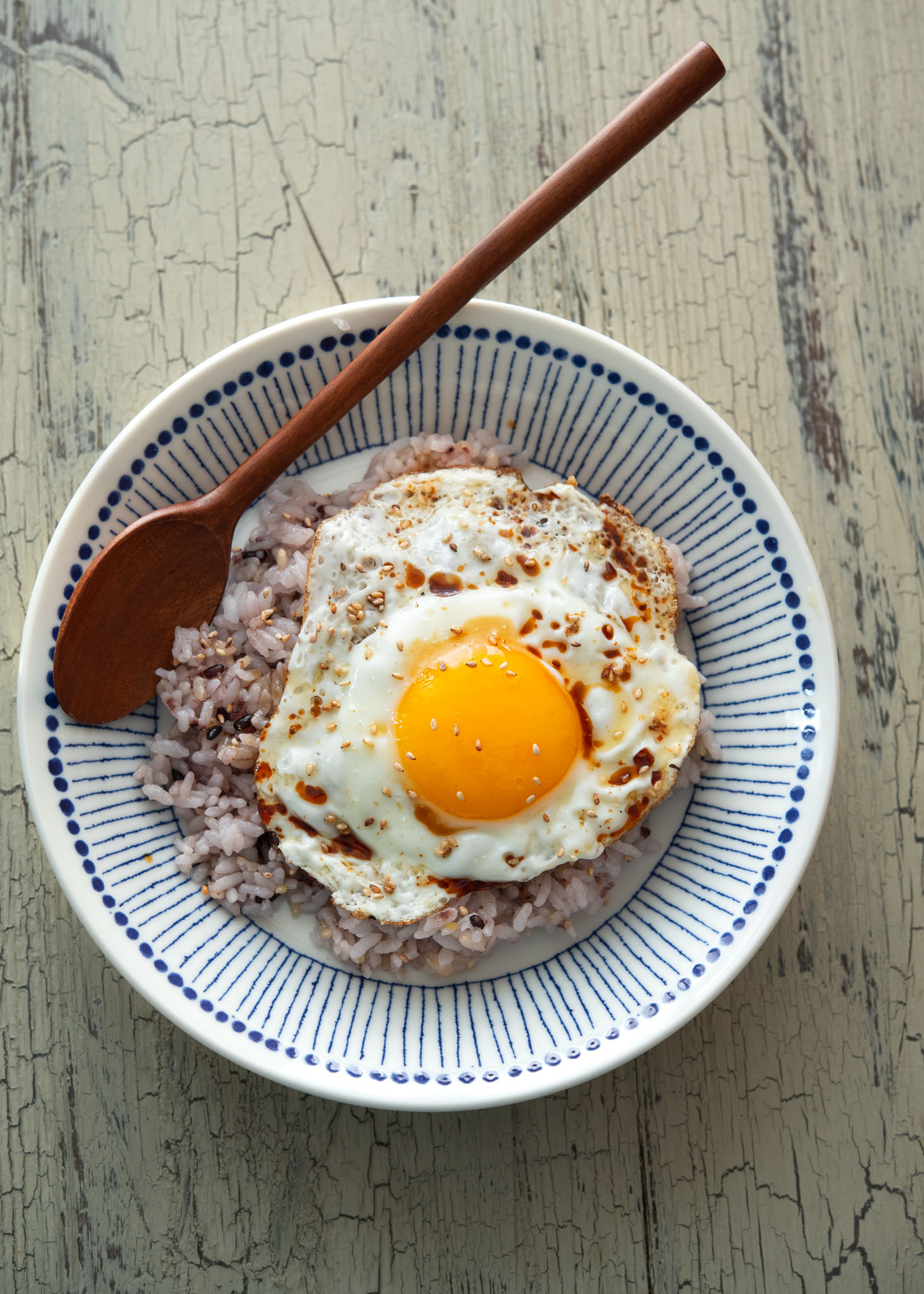 A bowl of gyeran bap (Korean fried egg with rice) with sesame seeds topping.