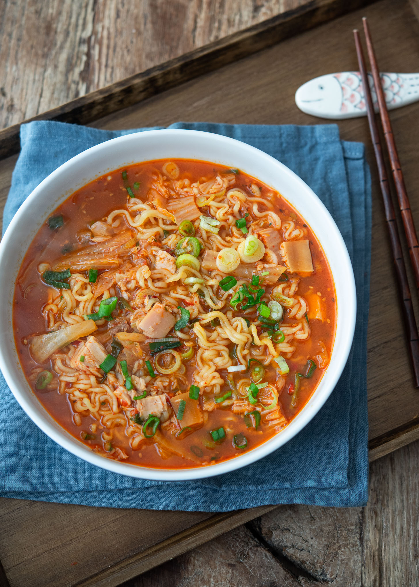 A bowl of kimchi ramen (ramyeon) served on a tray with a pair of chopsticks.