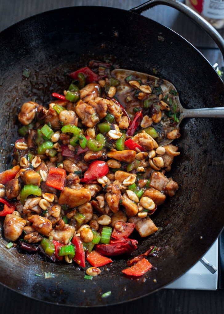 Sichuan Kung pao chicken is finished cooking in a wok.